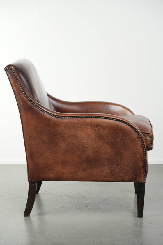 Image 1 of Bellissima poltrona in pelle di pecora in buone condizioni, con un bel colore intenso e una seduta confortevole.