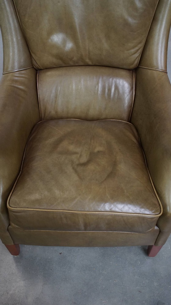 Image 1 of Poltrona in pelle di mucca verde oliva rifinita con chiodi decorativi