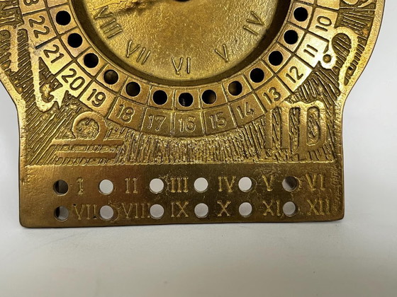 Image 1 of Mid-century brutalist brass zodiac desk clock met datumkalender – 1960s West Germany