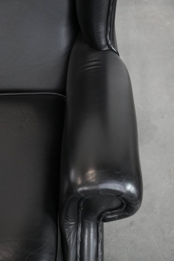 Image 1 of Smooth black cowhide Chesterfield wingback armchair in English style with color-matched piping