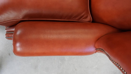 Image 1 of Elegante en comfortabele gladde Engelse rundleren chesterfield oorfauteuil met sierlijke pootjes