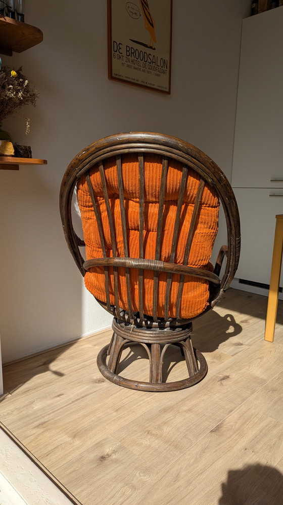 Image 1 of Draaibare rotanstoel uit de jaren 70 met oranje corduroy kussen