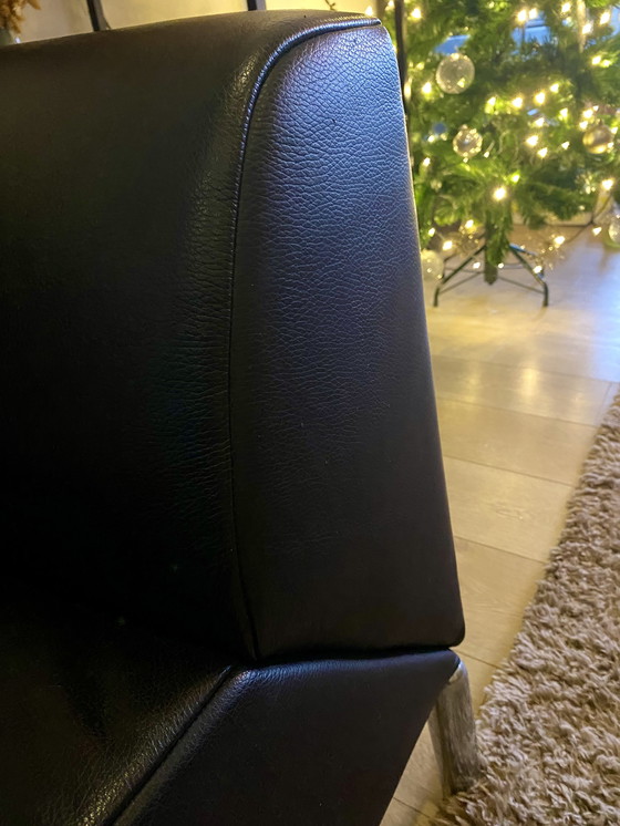 Image 1 of Sofá de diseño en piel negra con reposabrazos regulables.