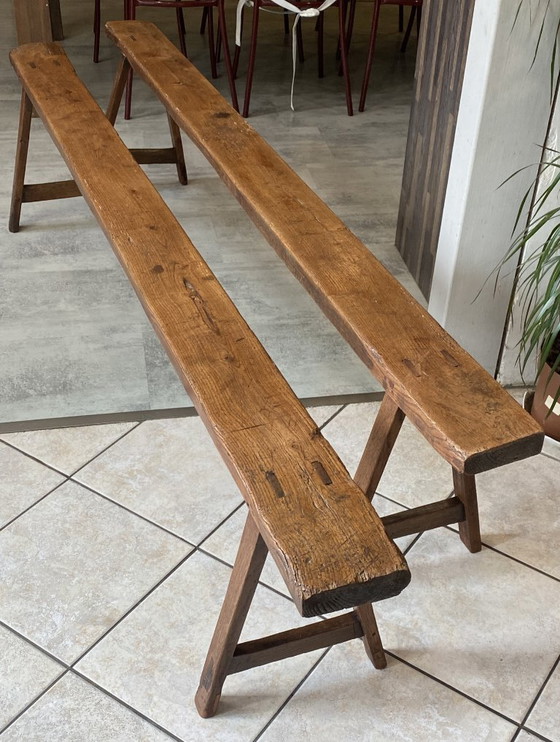 Image 1 of Twee massief eikenhouten boerenbanken van 214 cm voor een rustieke boerentafel uit de jaren 50.