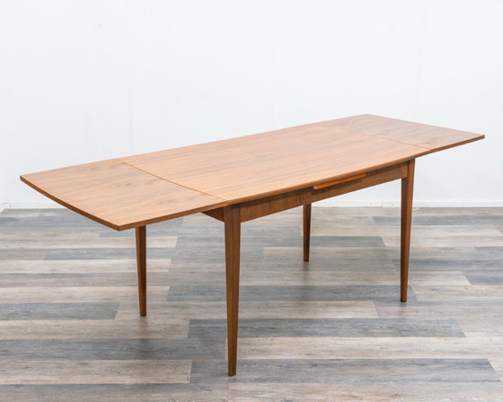 Image 1 of Tavolo da pranzo, anni '60, in noce, di forma leggermente ellittica.