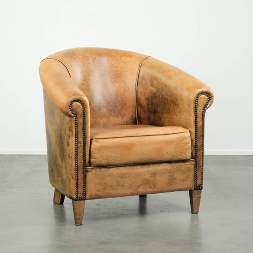 Vintage sheepskin leather club armchair in light cognac with decorative nails and beautiful patina