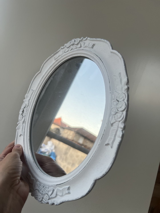 Image 1 of Specchio ovale in legno bianco con intagli floreali.