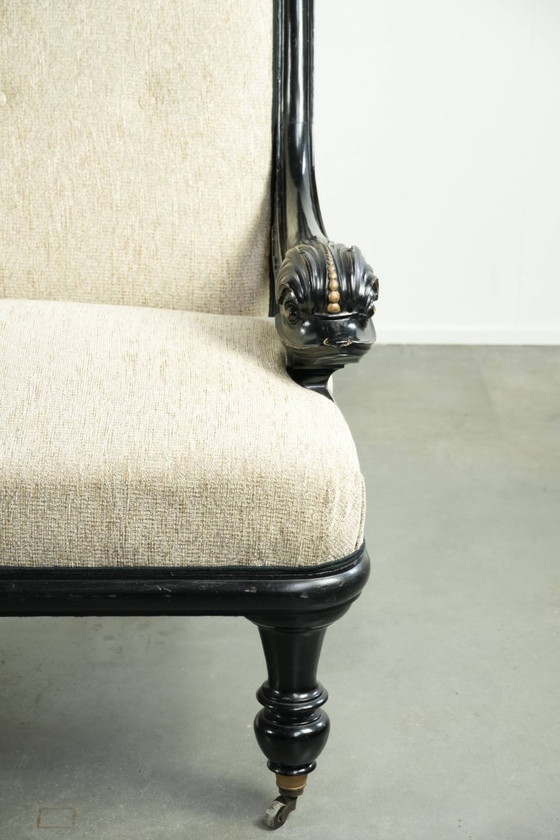 Luxurious 19th-century French sofa in Empire style with cream-colored fabric and uniquely detailed armrests. (photo 9 of 13)