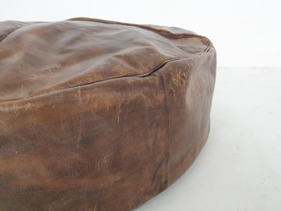 Image 1 of Dark brown leather ottoman. In good vintage condition