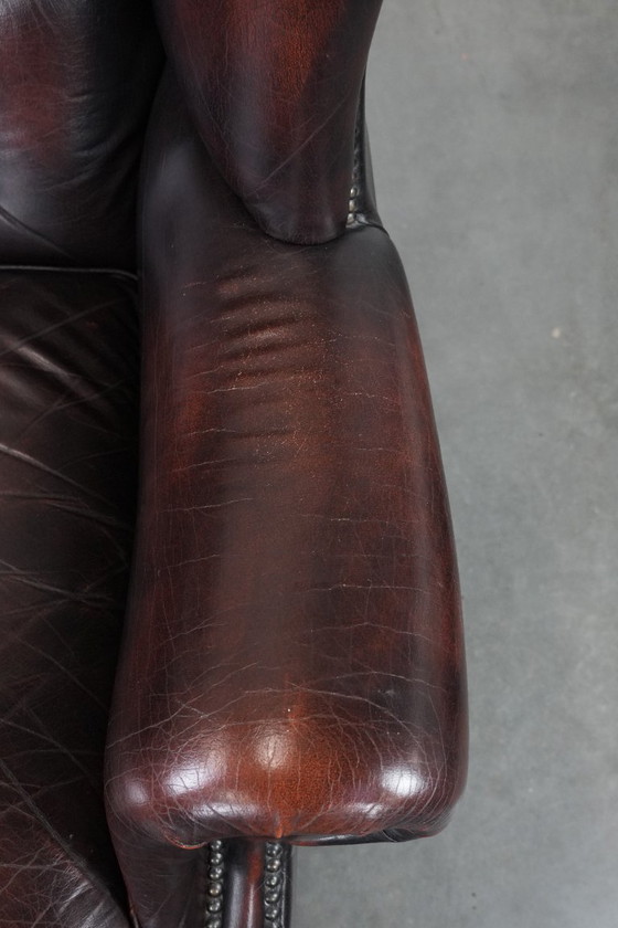 Image 1 of Poltrona Chesterfield con braccioli in pelle bovina marrone, in classico stile inglese.
