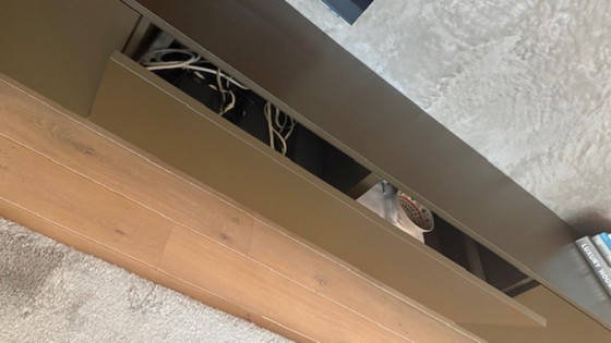 Image 1 of brown wall cupboard (possibly for under TV) with 3 folding doors