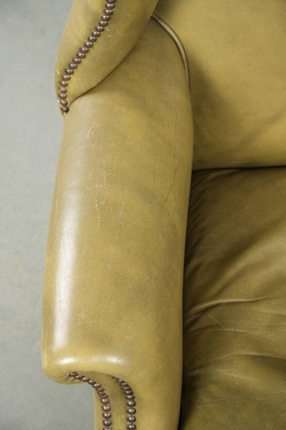 Image 1 of Fauteuil à oreilles ancien et élégant en cuir de vachette vert, de style classique de maison de campagne anglaise.