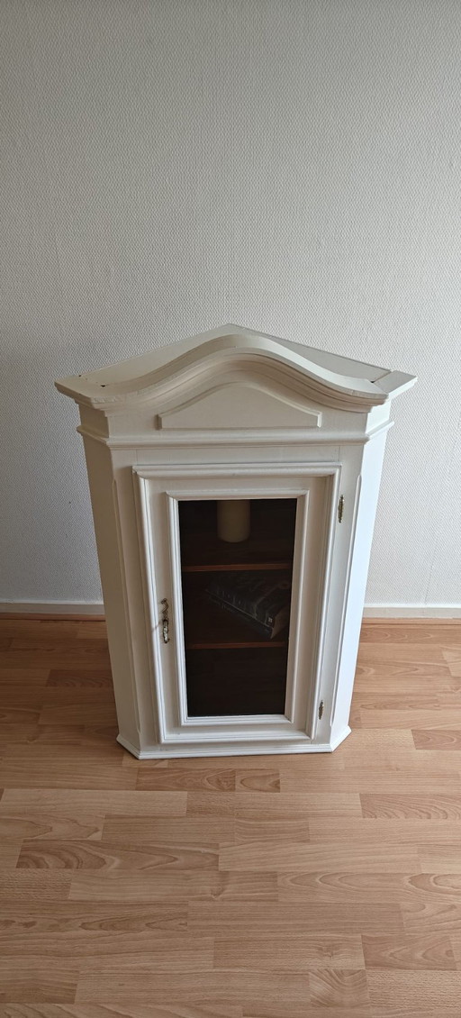 Mueble esquinero blanco restaurado con detalles en marrón oscuro.