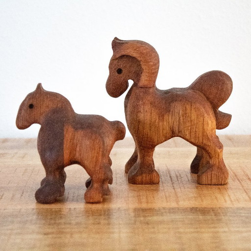 Dos figuras de caballos de madera talladas a mano, yegua y potro, en un estilo de arte popular holandés minimalista