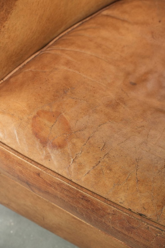 Image 1 of Vintage sheepskin club armchair with beautiful colors and finished with decorative nails.