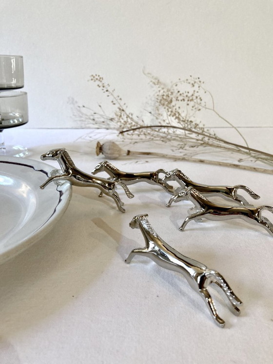 Image 1 of Cinco reposacuchillos de metal plateado con forma de caballo. Años 60.