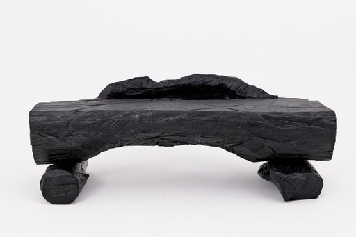 Bank van massief verkoold hout van Logniture – een organisch, modern en sculpturaal zitmeubel.