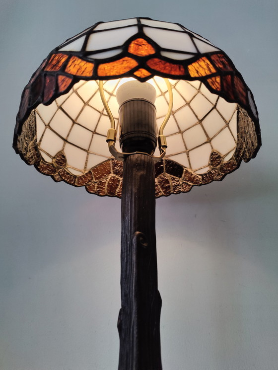 Image 1 of Lámpara de mesa estilo Tiffany con pantalla de vidrieras y base de bronce.