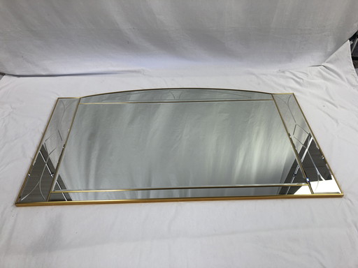 Large faceted mirror framed in brass