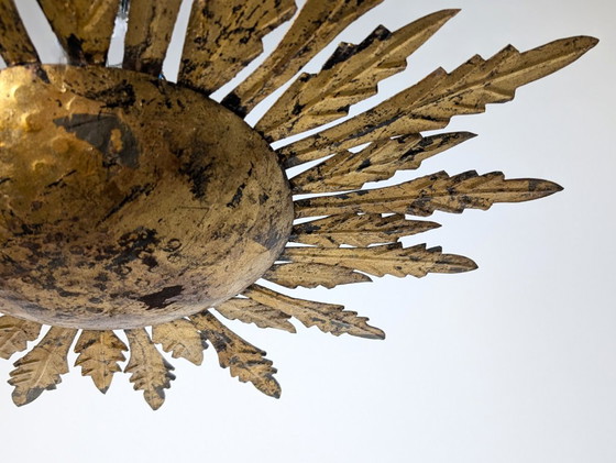 Plafondlamp met verguld metalen ontwerp in de vorm van een zonnestraal met bladmotieven, uit het midden van (photo 4 of 9)