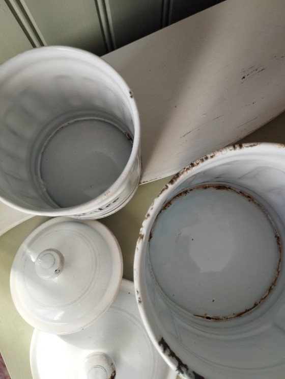 Image 1 of Antieke dozen gemaakt van wit geëmailleerd plaatmetaal met gegroefde randen en gouden versiering.