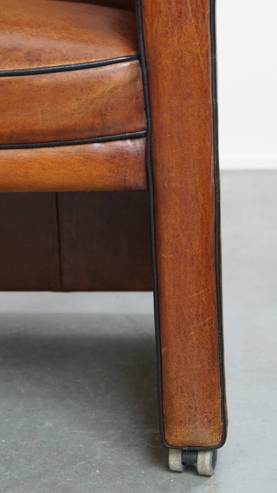 Image 1 of 4 x Vintage schapenleren eetkamerstoel met zwarte biezen op wieltjes