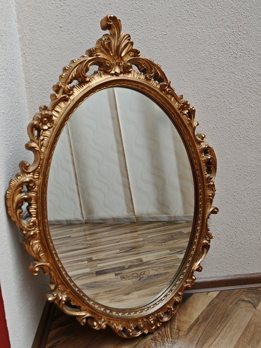 Oval mirror with golden wooden frame from an estate