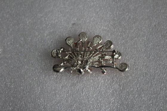 Image 1 of Gebogen broche met honingkleurige glazen steentjes op een zilverkleurig metalen frame, vintage uit de jaren 80.