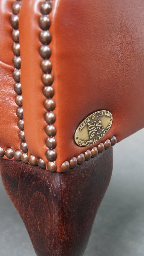 Image 1 of Elegante en comfortabele gladde Engelse rundleren chesterfield oorfauteuil met sierlijke pootjes