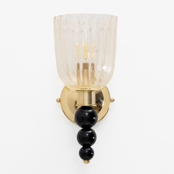 Image 1 of Een paar Italiaanse wandlampen van Murano-glas met goudstofaccenten en messing.