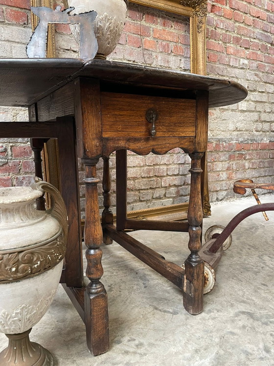 Image 1 of Tavolo antico in rovere con gambe a ribalta e cassetto