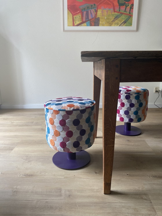 Conjunto único de muebles reciclados: dos pufs con diseño de McDonald's retapizados sobre bases de acero. (photo 7 of 11)