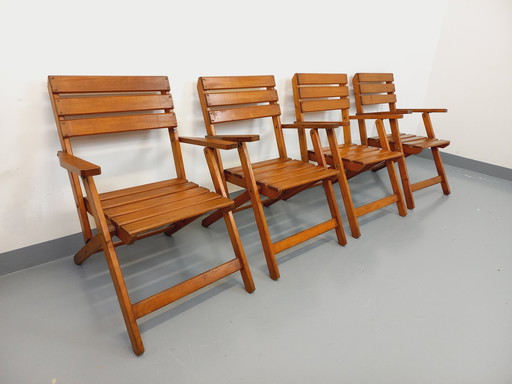 Vintage garden furniture consisting of a table with extensions and 4 wooden armchairs from the 60s