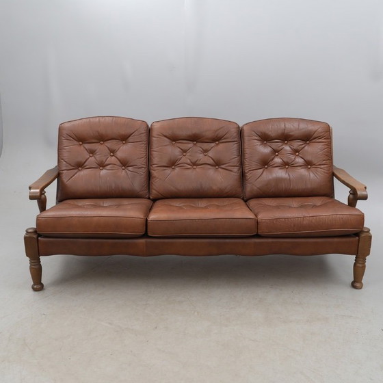 Image 1 of A vintage brown three-piece sofa set in leather with wooden armrests and turned legs, comprising a 1-seater, 2-seater and 3-seat