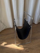 Portariviste vintage con struttura tubolare cromata e rivestimento in pelle nera.