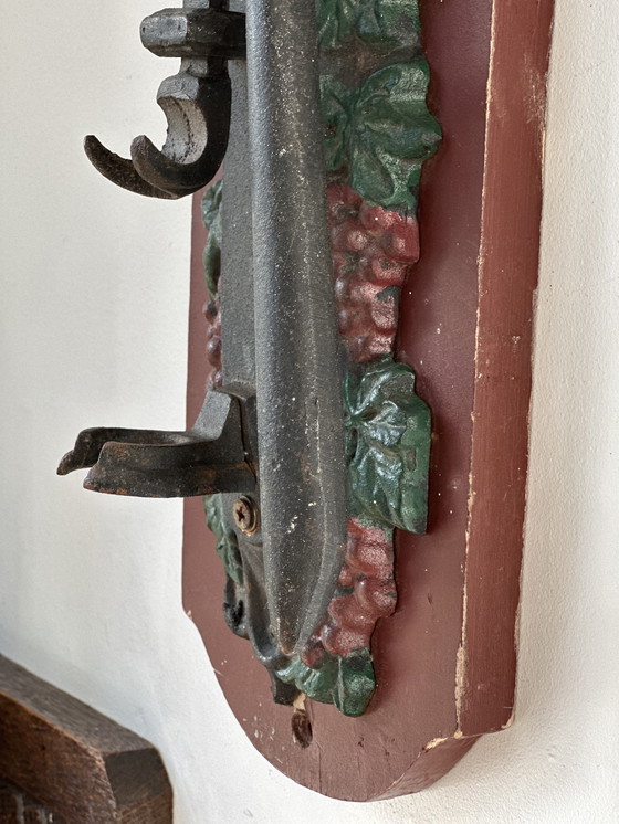 Image 1 of Ouvre-bouteille mural ancien en fonte à motif de raisin – style auberge (vers 1900)