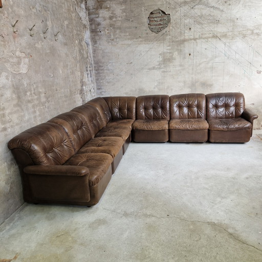Sofá modular de los años 70 con elementos marrones y sofá de cuero.