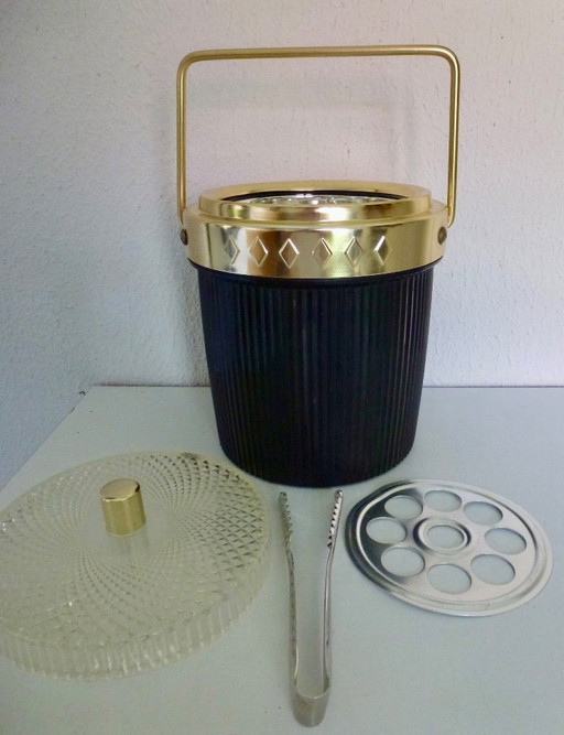 Seau à glace noir vintage avec détails dorés et couvercle en plastique transparent.