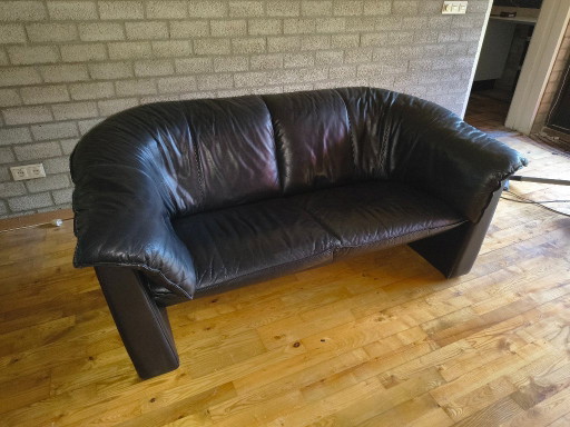 Two identical, black, leather Leolux sofas