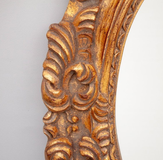 Image 1 of Oval mirror, gilded and carved from wood. Exclusive vintage mirror, handmade by expert artisans.