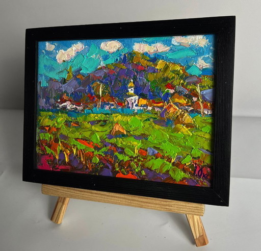 Origineel olieverfschilderij: Landelijk landschap. Een dorp is in de verte te zien.