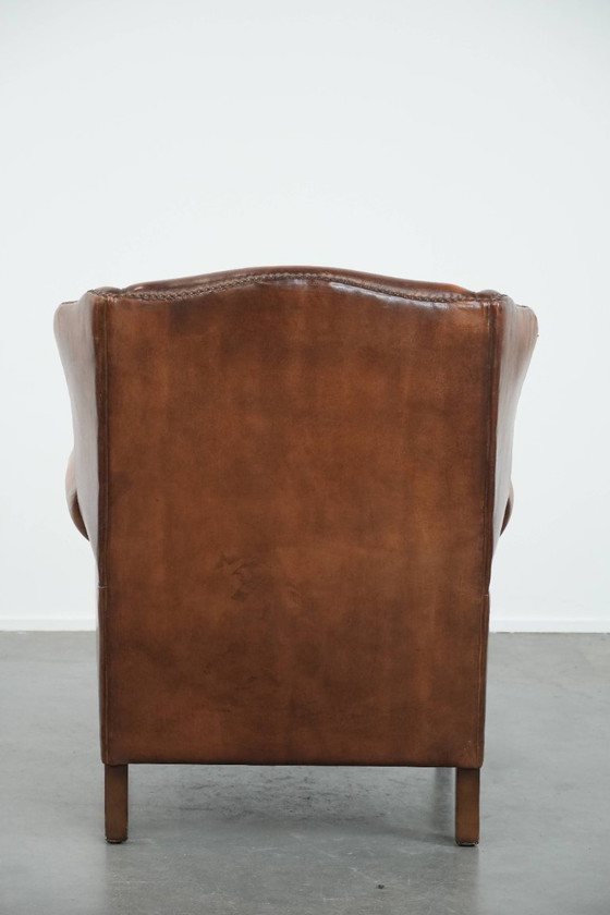 Image 1 of Sillón orejero de piel de oveja acabado con clavos decorativos