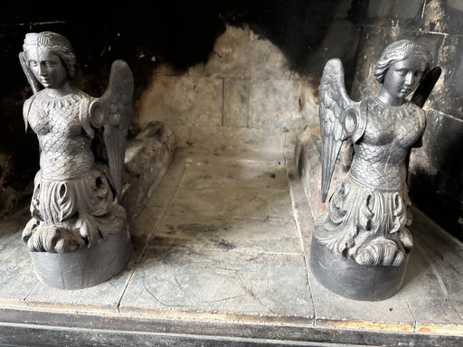 Twee antieke vuurbokken met vrouwenfiguren (Jeanne d'Arc?)