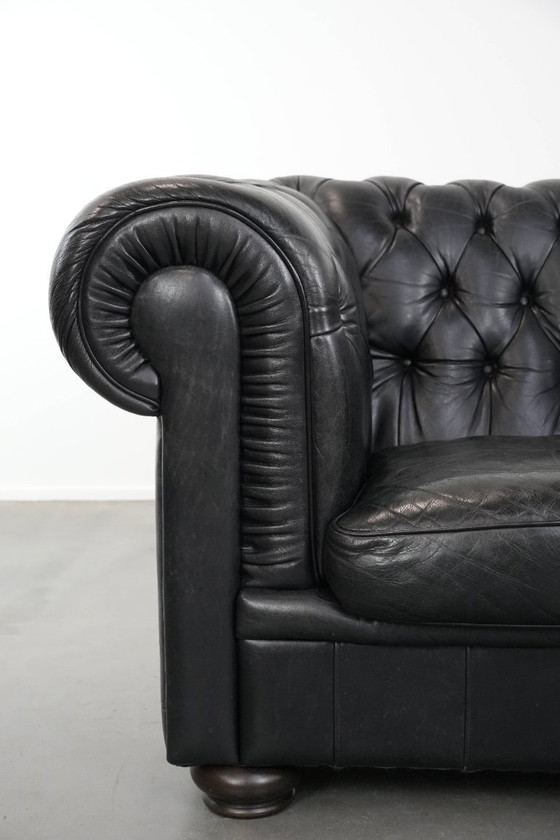 Image 1 of Set consisting of a black Chesterfield sofa, armchair and footstool made of cowhide