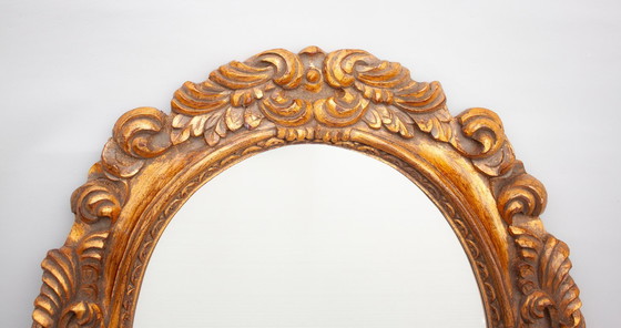 Image 1 of Oval mirror, gilded and carved from wood. Exclusive vintage mirror, handmade by expert artisans.
