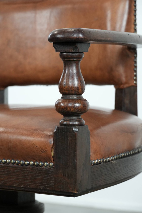 Image 1 of Elegante antieke schapenleren bureaustoel met een zwaar houten frame