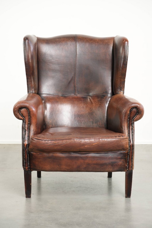 Spacious vintage sheepskin wing armchair in a deep brown color, finished with decorative nails. – fauteuils (photo 2 of 17)