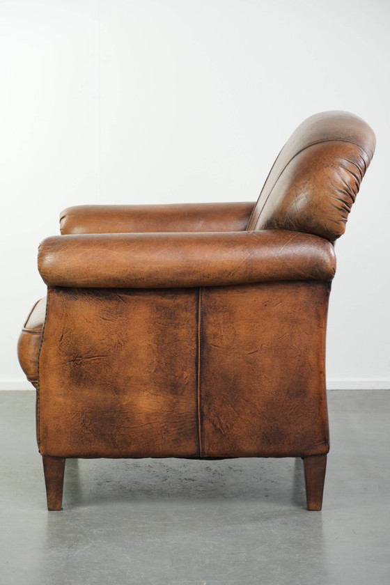 Comoda poltrona in pelle di pecora, dal carattere deciso, rifinita con borchie decorative e una splendida (photo 5 of 13)