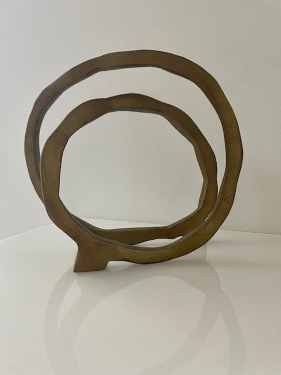 Image 1 of Escultura de diseño con forma de anillo abierto en oro mate.