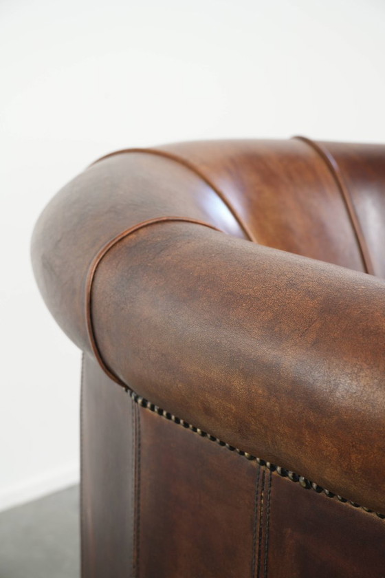 Sturdy and characterful sheepskin club armchair with a beautiful patina, finished with decorative nails. (photo 10 of 12)